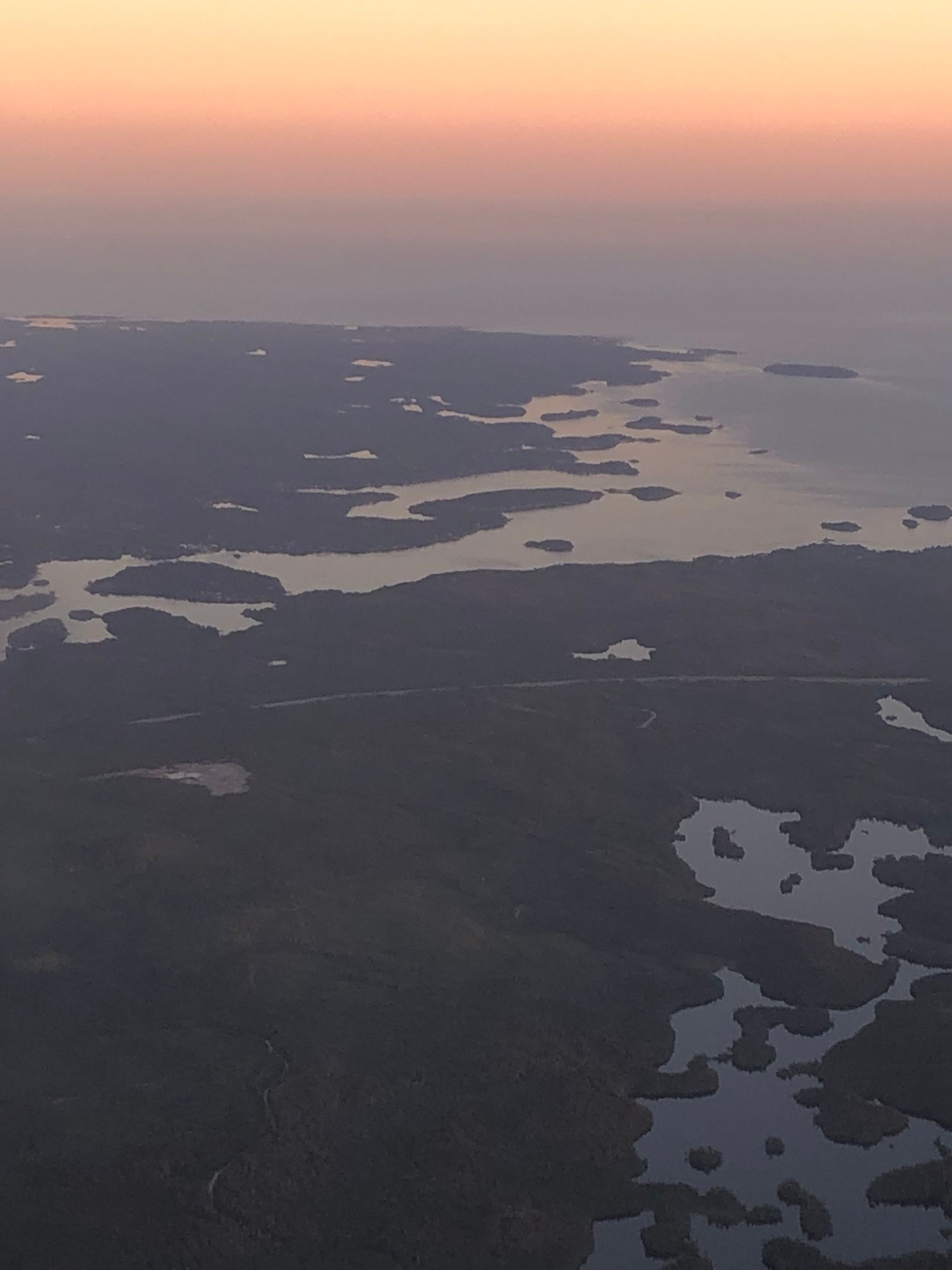 A sunset sky over the coastal edges of Nova Scotia, the water catching some of the fading light.