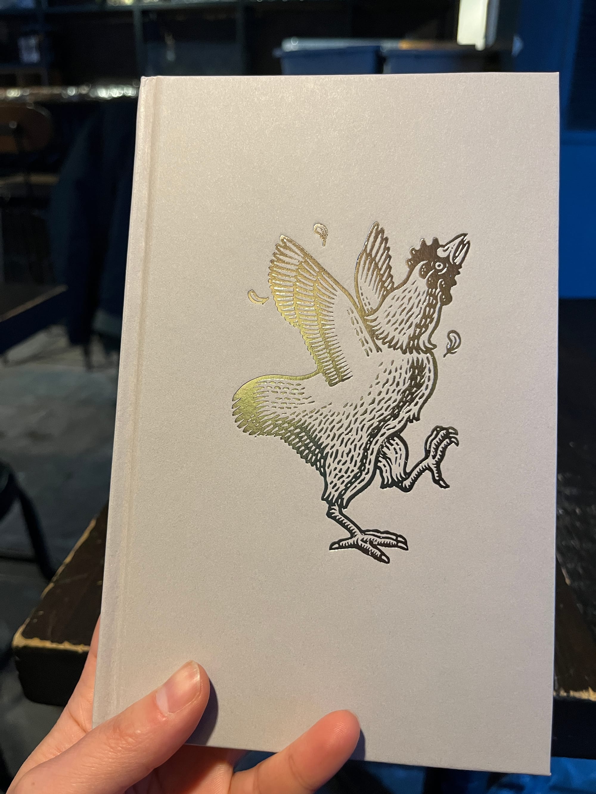 The book held at a flatter angle to showcase the shine on the chicken.